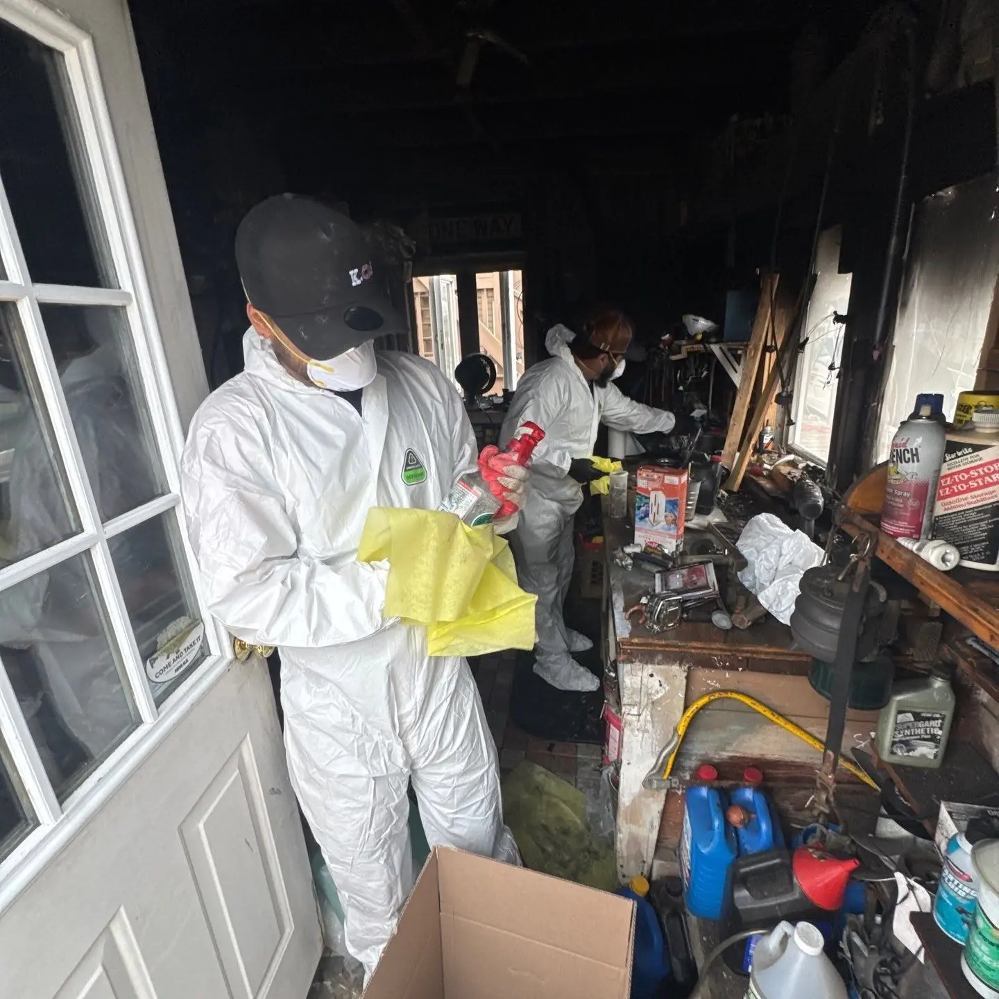 K.O.S. crew in PPE cleaning soot-damaged contents after a garage fire
